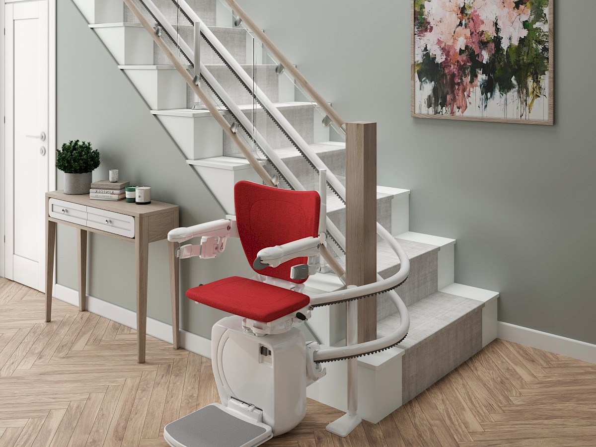 Sitzlift mit rotem Sitz an einer Treppe in einem hellen Flur