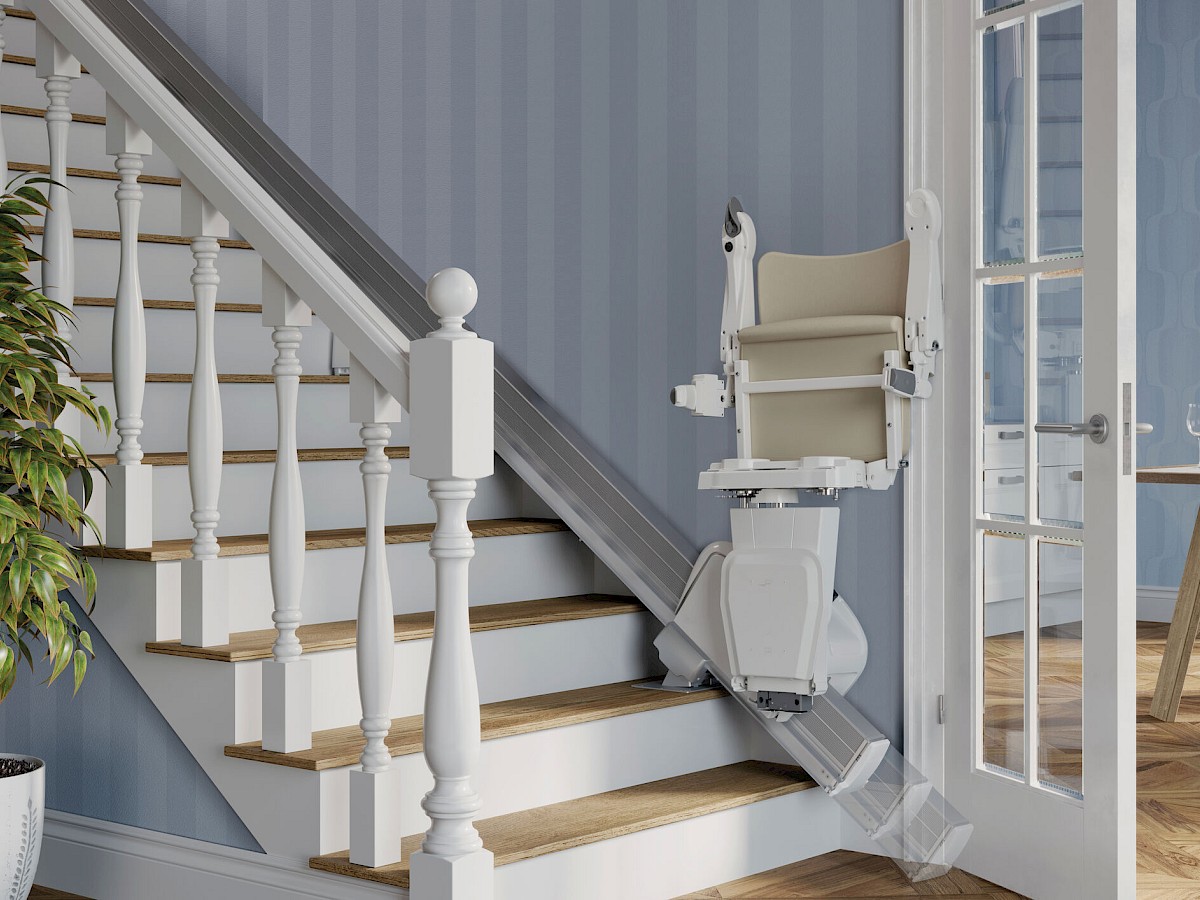 Sitzlift an einer Treppe mit wei&szlig;em Gel&auml;nder und blaugrauer Wand in einem Wohnhaus